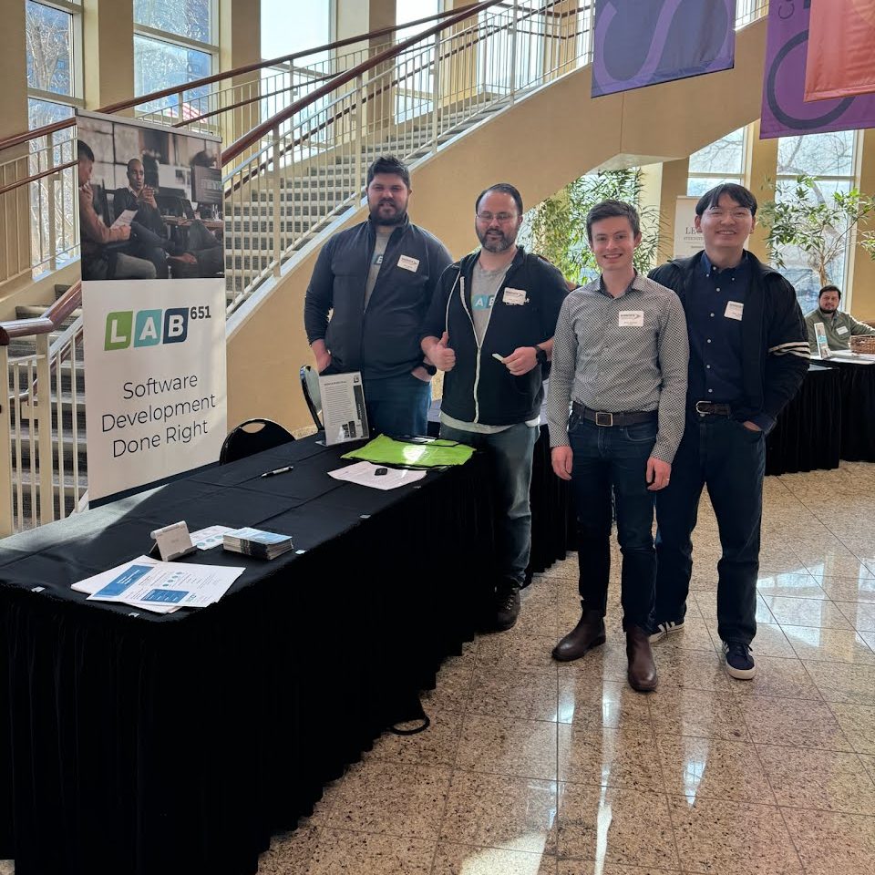 Members of the Lab651 team at a Lab651 booth beside a Software Development Done Right banner